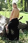 Somewhere in the woods beautiful blonde Iveta Vale loses her black wrap and poses naked